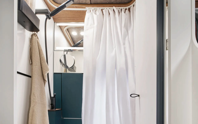 The shower curtain protects the toilet, shelves and walls from splashing water while showering.