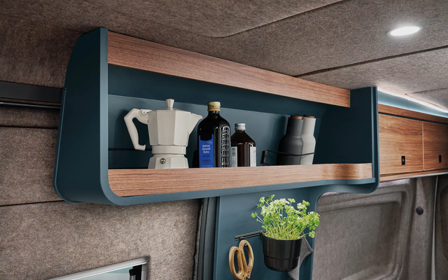 Practical storage compartments above the kitchen create order and quick access to everyday utensils.
