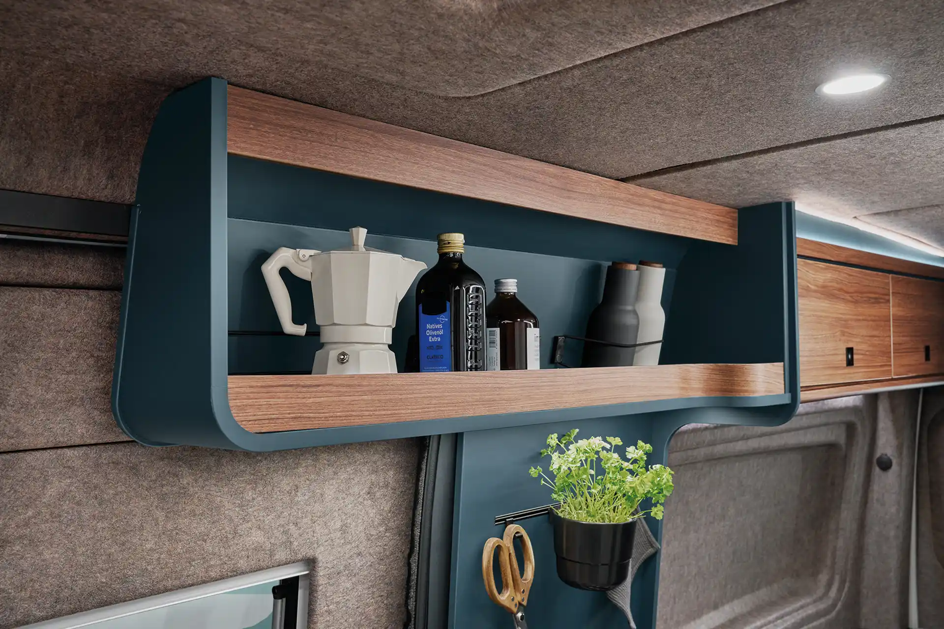 Practical storage compartments above the kitchen create order and quick access to everyday utensils.