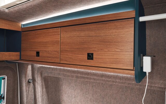 Practical storage compartments and integrated power outlets above the bed ensure order and comfort.