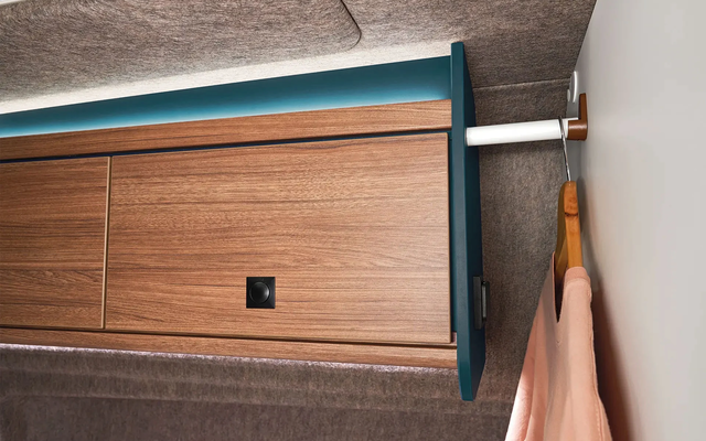 Overhead storage cabinets and integrated clothes rails offer practical storage options for clothing and luggage.