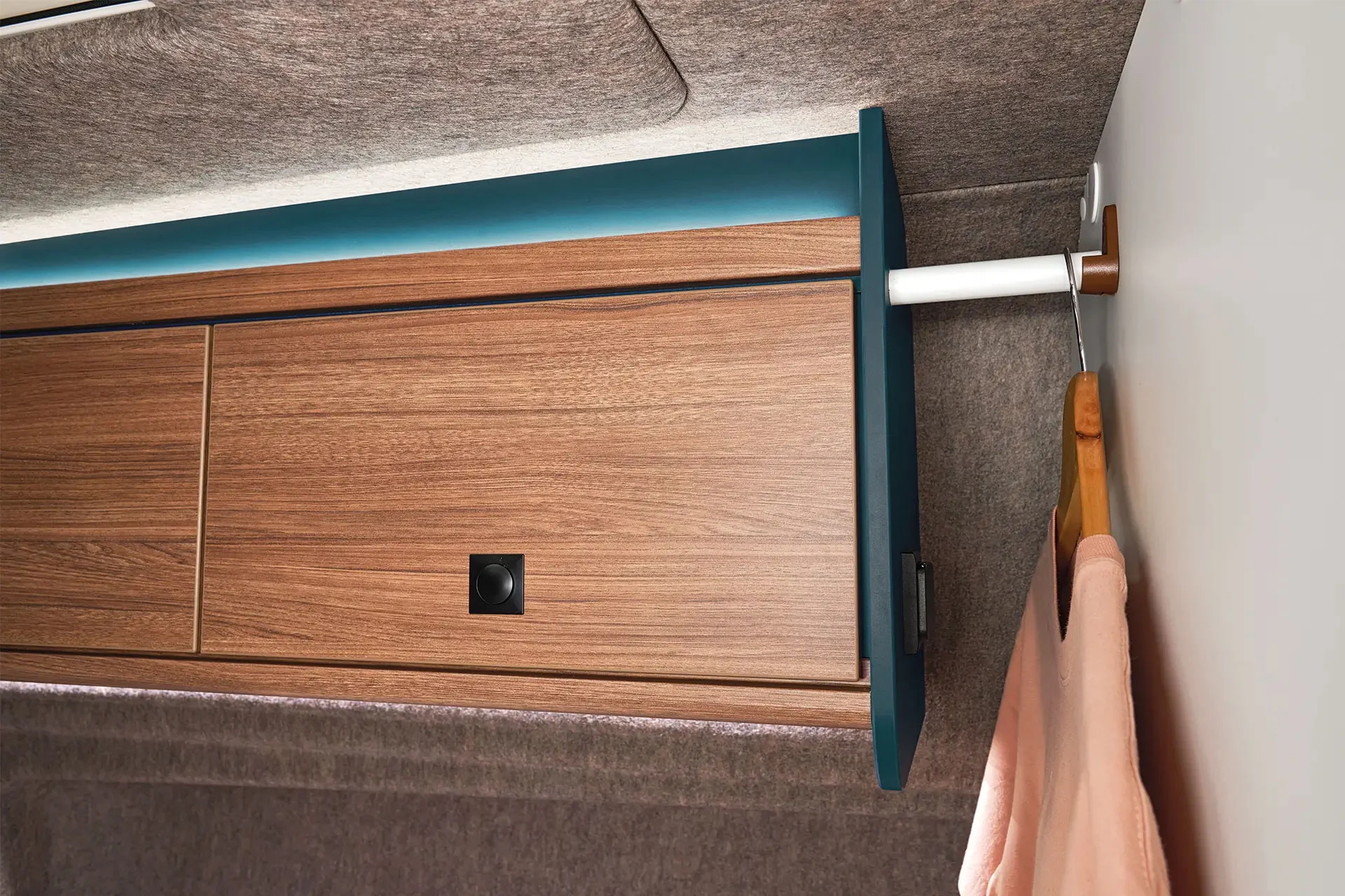 Overhead storage cabinets and integrated clothes rails offer practical storage options for clothing and luggage.